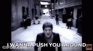 Black And White Photo Of Man In Alleyway With Band GIF