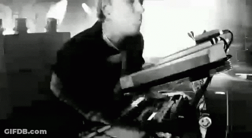 Black And White Photo Of Man Playing Keyboard On Stage GIF