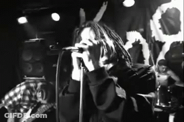 Black And White Photo Of Man Singing Into Microphone GIF