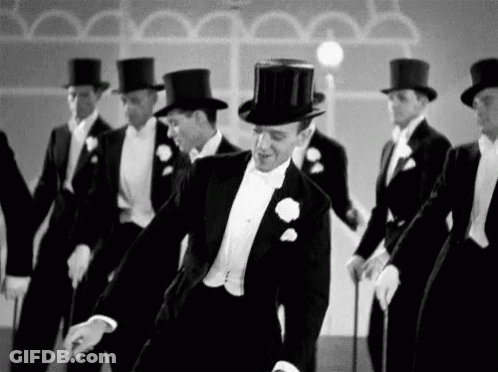 Black And White Photo Of Men In Tuxedos And Top Hats Dancing GIF