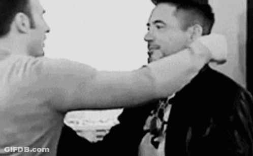 Black And White Photo Of Two Men Hugging One In Suit And Tie GIF