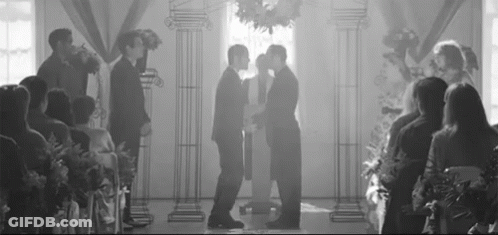 Black And White Photo Of Two Men Kissing At Wedding GIF