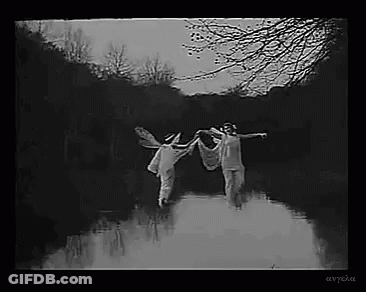 Black And White Photo Of Two People Holding Hands In River GIF