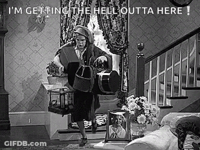 Black And White Photo Of Woman Holding Bag In Living Room GIF