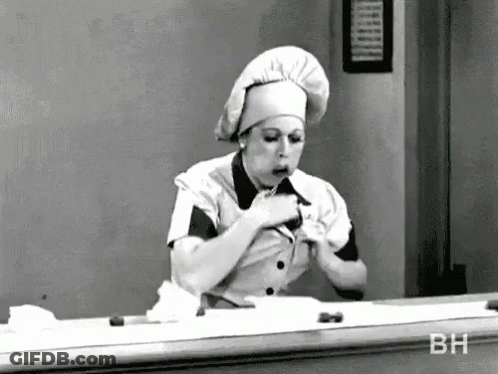 Black And White Photo Of Woman In Chef Hat Eating GIF