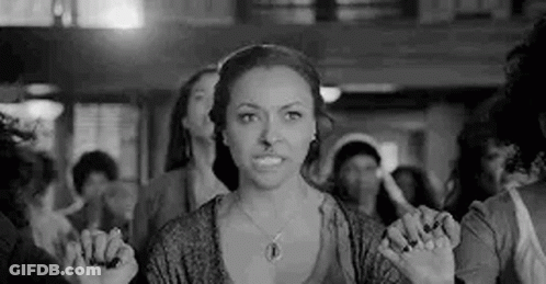 Black And White Photo Of Woman In Crowd Holding Hands Together GIF