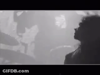 Black And White Photo Of Woman In Front Of Crowd GIF