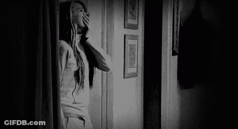 Black And White Photo Of Woman Looking Out Doorway GIF