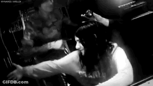 Black And White Photo Of Woman Sitting In Dark Room GIF