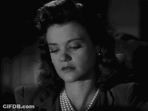 Black And White Photo Of Woman With Pearl Necklace And Earrings GIF