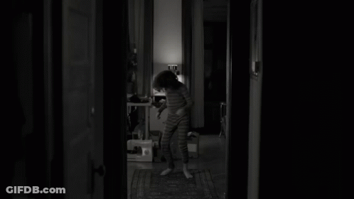 Black And White Photo Of Young Boy In Dark Room GIF