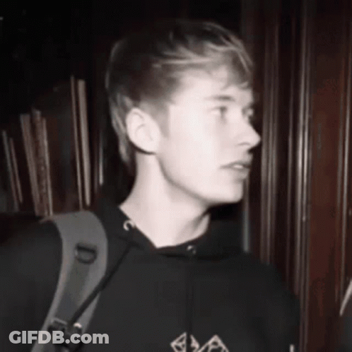 Black And White Photo Of Young Man In Hoodie With Backpack GIF