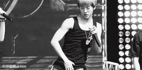 Black And White Photo Of Young Man Singing Into Microphone GIF