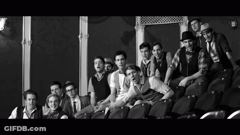 Black And White Photo Of Young Men Sitting In Theater GIF