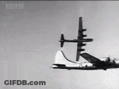 Black And White Plane Flying Through Blue Sky GIF