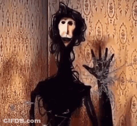 Black And White Puppet In Front Of Spider Web GIF