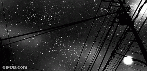 Black And White Starry Night Sky With Telephone Wires And Street Light GIF
