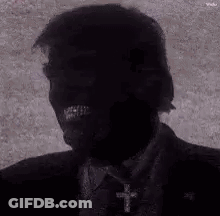 Black And White Suited Man With Cross Necklace GIF