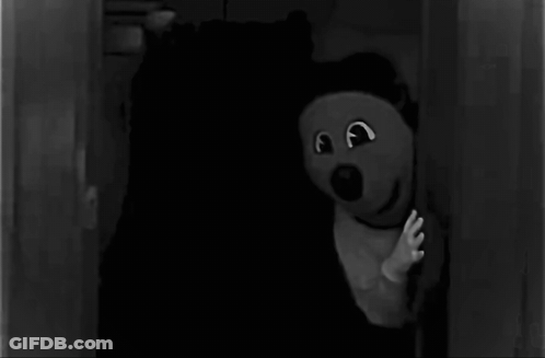 Black And White Teddy Bear In Dark Room GIF