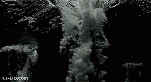 Black And White Wave Crashing On Rocky Shore GIF