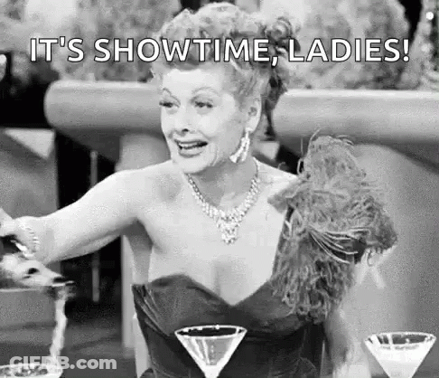 Black And White Woman In Dress Sitting At Table With Martinis GIF