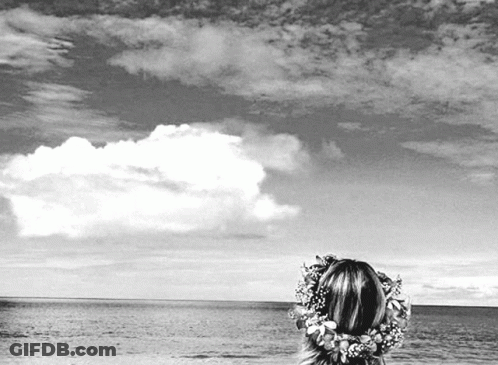 Black And White Woman Looking Over Ocean With Flower Crown GIF