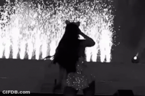 Black And White Woman On Stage With Fireworks GIF