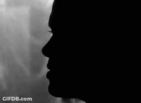 Black And White Woman's Face In Dark GIF