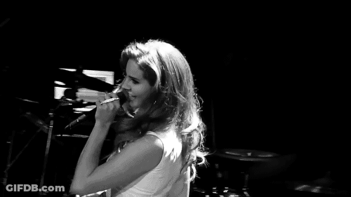 Black And White Woman Singing Into Microphone On Stage GIF