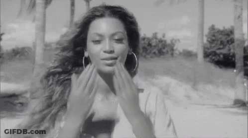 Black And White Woman With Hoop Earrings Touching Face GIF