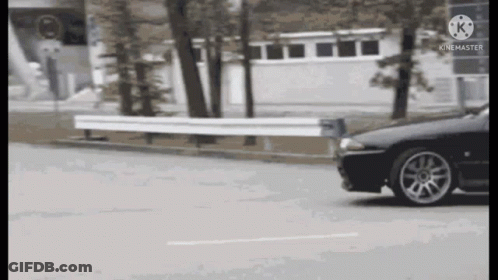 Black Car Driving Past White Fence GIF