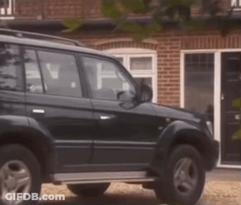 Black Car Parked In Front Of Brick House GIF