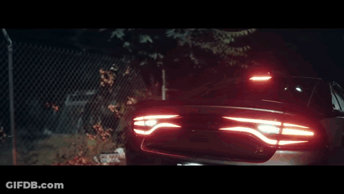 Black Car Parked In Front Of Fence GIF