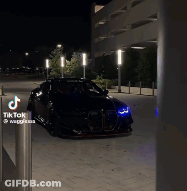Black Car Parked Next To Tik Tok Sign GIF