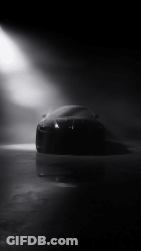 Black Car Silhouetted Against Spotlight In Dark GIF