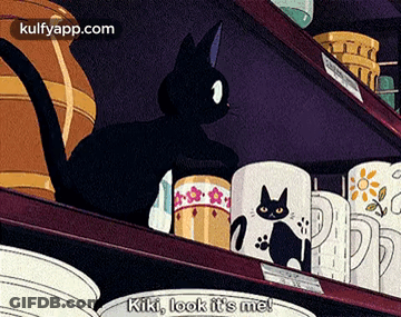 Black Cat On Shelf With Mugs Says Kiki Look It's Me GIF