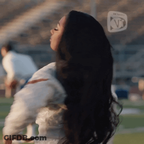 Black-Haired Woman Standing On Football Field KT Logo GIF