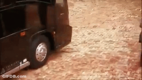 Black Limousine Driving On Cobblestone Street GIF