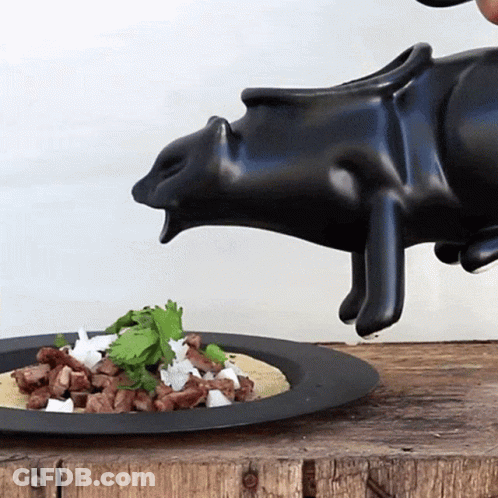 Black Pig Statue Pouring Liquid Over Food GIF
