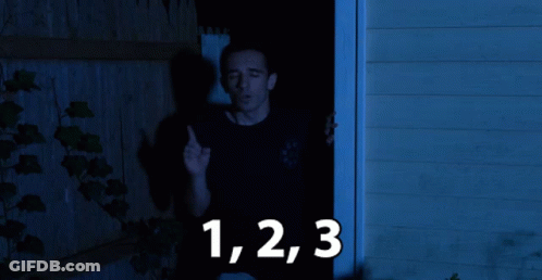 Black Shirt Man At Doorway With Numbers 1 2 3 GIF