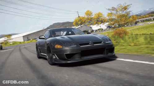 Black Sports Car Driving Down Road Near Field GIF