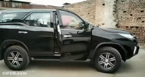 Black SUV Parked In Front Of Brick Wall GIF
