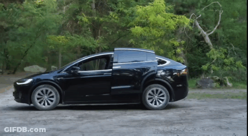 Black Tesla Model X Parked On Dirt Road With Doors Open GIF