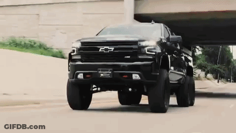 Black Truck Driving Under Bridge On City Street GIF