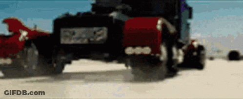 Black Truck With Red Hood Driving On Sandy Beach GIF