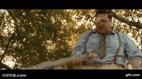 Blindfolded Man In Suspenders Holding Sword GIF