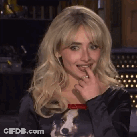 Blonde Woman In Black Dog Shirt Licking Lips GIF