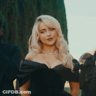 Blonde Woman In Black Dress Standing In Front Of Man GIF