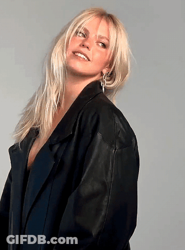 Blonde Woman In Black Leather Jacket And Earrings GIF