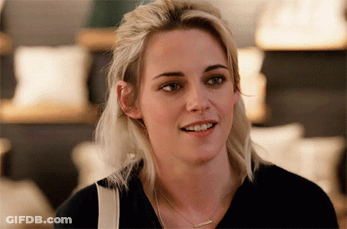 Blonde Woman In Black Shirt And Necklace Smiling GIF